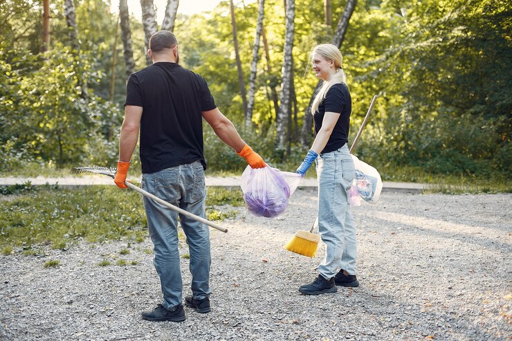 couple-collects-garbage-garbage-bags-park_1157-27400